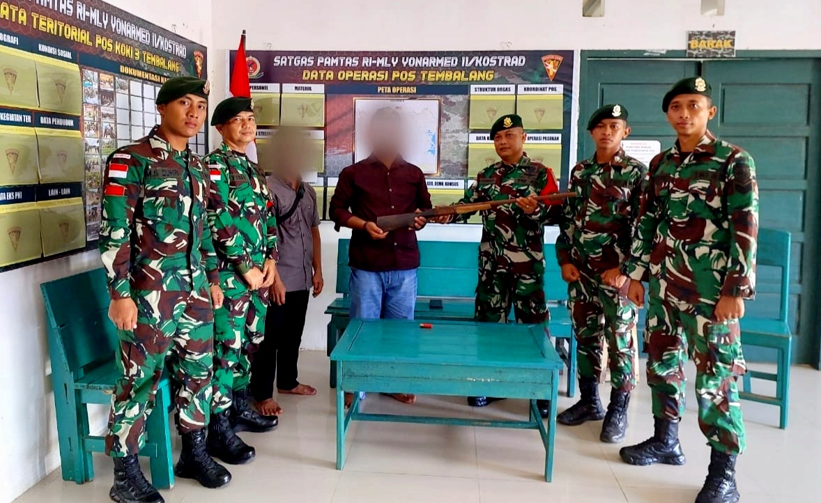 Seorang warga di perbatasan menyerahkan sepucuk senjata api Laras panjang, Kamis (31/10/2024)