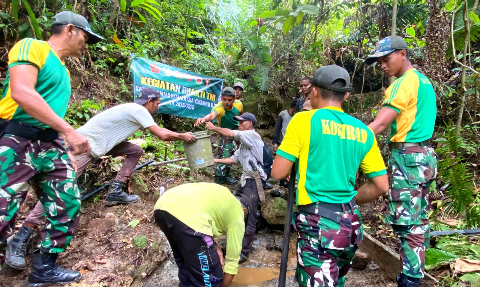 Prajurit Satgas Pamtas Yonarmed 11 Kostrad bersama warga membangun saluran mata air, Sabtu (02/11/2024). (foto: Peneleven/Narwan)