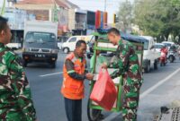 Prajurit Yonarmed 1 Kostrad melaksanakan berbagi kepada masyarakat di sekitar Jalan Singosari, Malang, Jumat (18/07/2025). (foto: Penajusta/Narwan) 