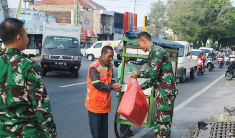 Prajurit Yonarmed 1 Kostrad melaksanakan berbagi kepada masyarakat di sekitar Jalan Singosari, Malang, Jumat (18/07/2025). (foto: Penajusta/Narwan) 